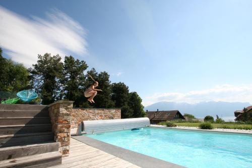 a person jumping off of a swimming pool at Montreux Holiday Home in Montreux