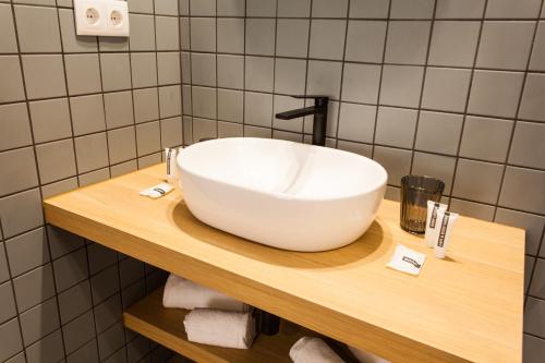 a bathroom with a white bowl sink on a wooden shelf at Hospedium H Cabo Sport in Finisterre