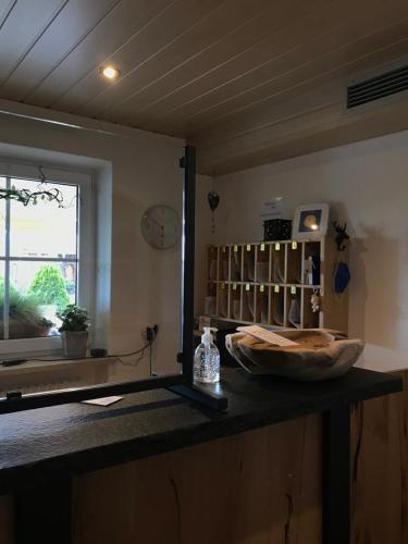 a counter in a room with a clock and a window at Zur neuen Post Landgasthof in Herzogsreut