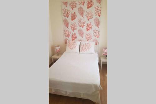 - une chambre avec un lit blanc aux murs roses dans l'établissement C069-Magnifique appartement au coeur du suquet, à Cannes