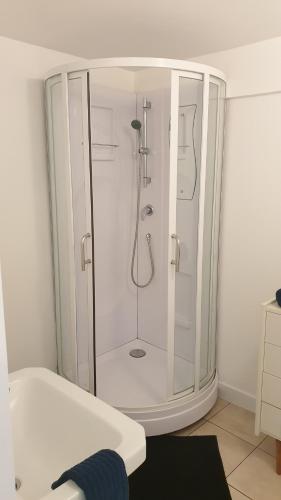 um chuveiro branco com uma porta de vidro na casa de banho em Gîte de l'Automne em Béthisy-Saint-Martin