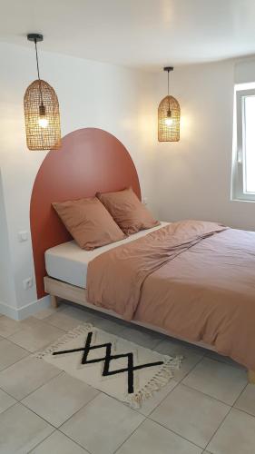 uma cama com uma cabeceira vermelha num quarto em Gîte de l'Automne em Béthisy-Saint-Martin