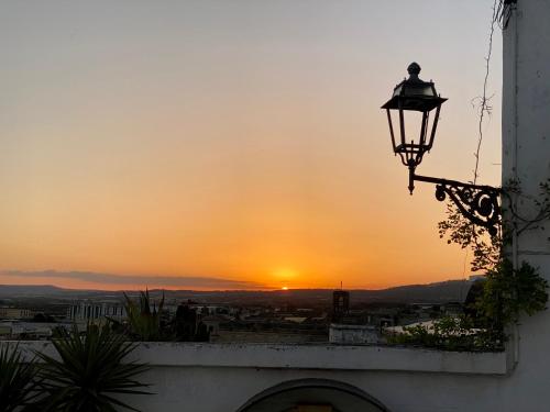 a street light with the sunset in the background at Le Dimore in Piazzetta in Massafra