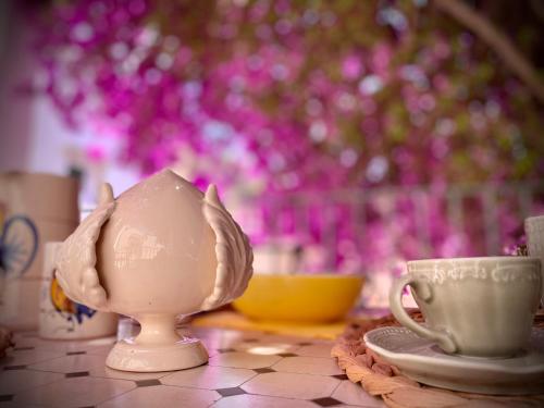 a table with a tea pot and cups on it at Le Dimore in Piazzetta in Massafra