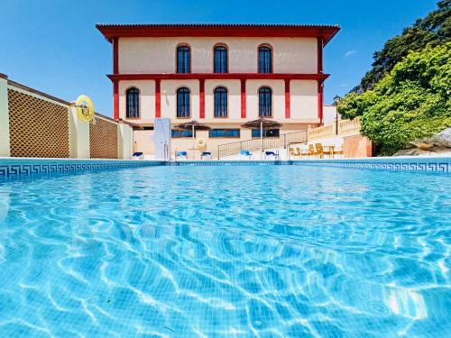 a swimming pool in front of a building at Hotel Sierra de Ubrique in Ubrique