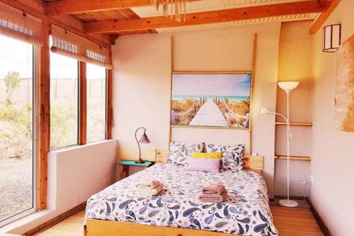 a bedroom with a bed and a large window at Tranquila Tierra - Eco Retreat Finca Artis Tirma in Tarajalejo