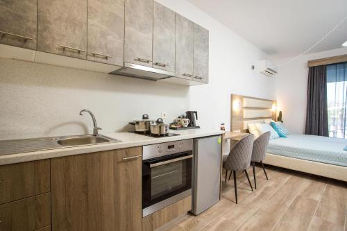 a kitchen with a sink and a bed in a room at Dimitra Faliraki Center Apartments in Faliraki