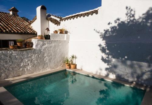 een zwembad voor een witte muur bij Casa De Los Cuadros in Villaluenga del Rosario