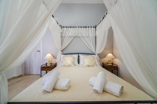 una camera con un letto bianco con due comodini di Stavros Villas a Karterados
