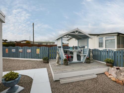 a house with a gazebo and a table at Sandpiper in Dumfries