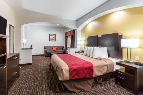a hotel room with a bed and a couch at Scottish Inns & Suites Spring - Houston North in Spring