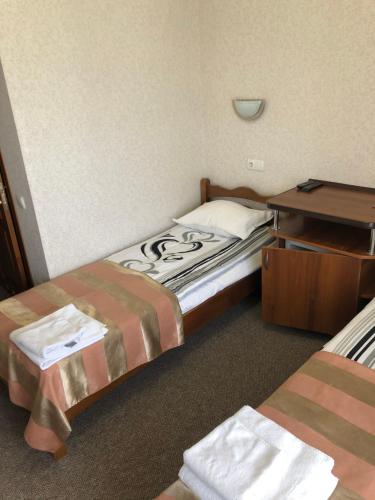 a hotel room with two beds and a desk at Motel Kurortnyy & SPA in Shklo