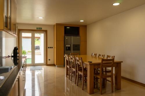 a kitchen with a wooden table and chairs at Casa Real - Royal Villa in Esposende
