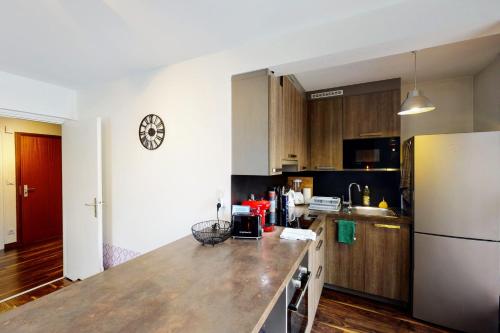 une cuisine avec un comptoir et un réfrigérateur dans l'établissement Le Berthollet 9 - Renovated apartment 1 bedroom 2 steps - Annecy center, à Annecy
