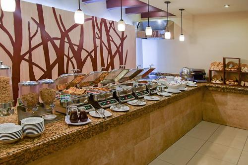 Una línea de buffet con platos de comida en un mostrador. en Holiday Inn Guatemala by IHG, en Guatemala