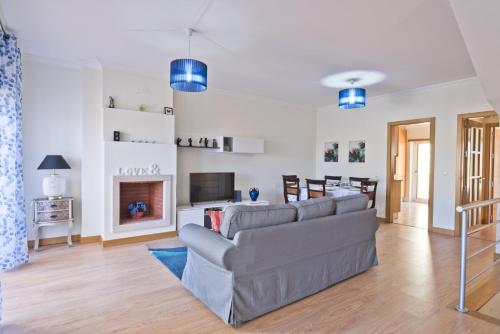 a living room with a couch and a fireplace at BmyGuest - Sesimbra Sea View Villa in Castelo