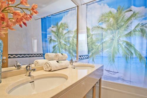 un bagno con due lavandini e una finestra di palma di BmyGuest - Sesimbra Sea View Villa a Castelo