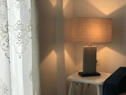a lamp sitting on a table next to a curtain at Unique Anoi House - In the Heart of Skyros Village in Skiros