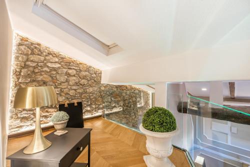 Zimmer mit einem Tisch mit einer Lampe und einer Steinmauer in der Unterkunft Sweet Holidays - Lerici e 5 Terre in Pitelli