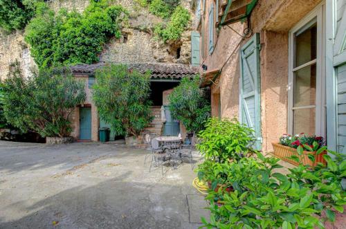 une cour avec une table et des chaises à côté d'un bâtiment dans l'établissement Hôtel Saint Jean, à Orange