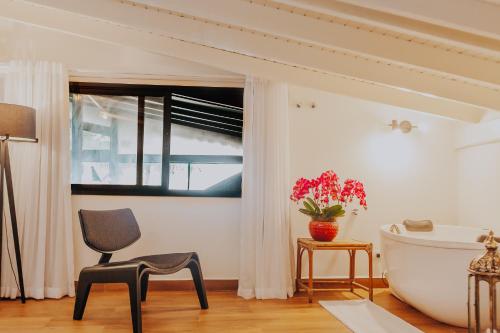 a bathroom with a bath tub and a chair and a bath tub at Chez Louise et Louis Pé na Areia in Juquei