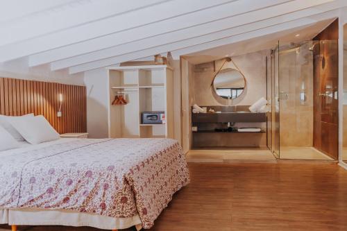 a bedroom with a bed and a bathroom with a sink at Chez Louise et Louis Pé na Areia in Juquei