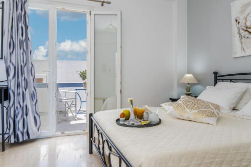 a bedroom with a bed with a tray of fruit on it at Stavros Villas in Karterados