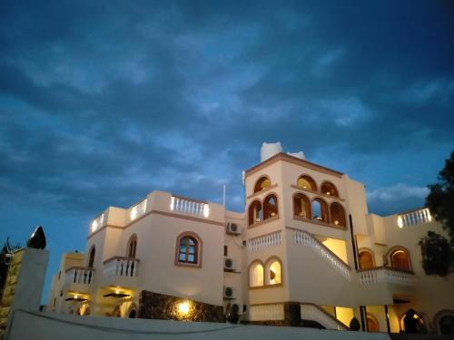 un gran edificio blanco con una torre de reloj por la noche en Villa 22 en Dahab