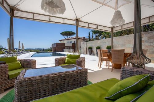 a patio with a table and chairs and a swimming pool at Villa Francesca Relais in Gradara