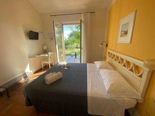een slaapkamer met een bed, een bureau en een raam bij La Visciola - Country House del Conero in Sirolo