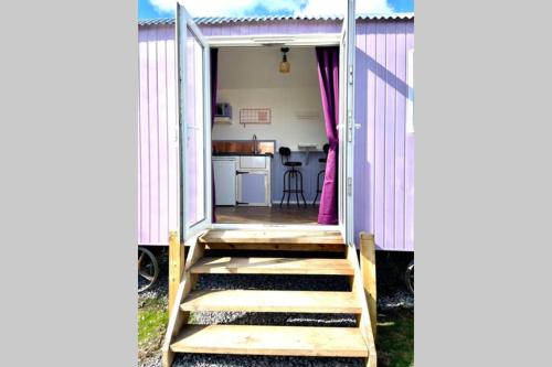 uma pequena casa com escadas que levam a uma cozinha em Lilac Tree Hut em Tenby
