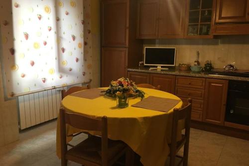 una cocina con una mesa amarilla con flores. en casa vacanze da Anna, en Vacri