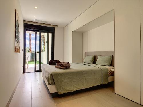 Schlafzimmer mit einem Bett und einer Glasschiebetür in der Unterkunft Hinojo227 Las Colinas Golf & Country Club in Orihuela