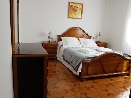 a bedroom with a wooden bed with a wooden floor at Mardes Novas 1 in Montesiños