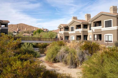 a row of houses with a bridge in the background at Raintree at Phoenix South Mountain Preserve in Phoenix