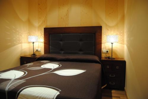 a bedroom with a bed and two lamps on two tables at Villa Adilia 