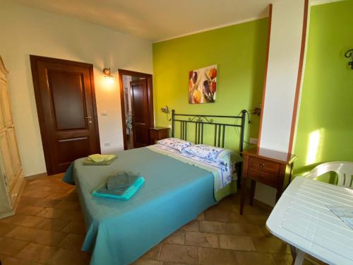 Un dormitorio con una cama azul y paredes verdes en B&b Su Acu, en Dorgali