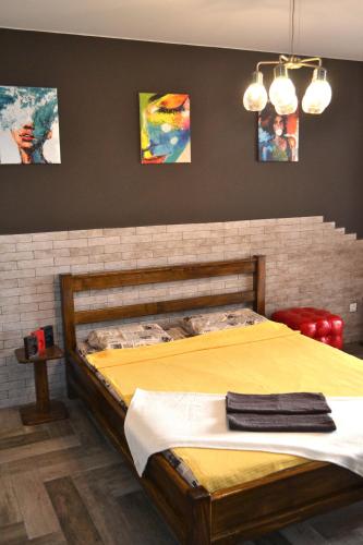 ein Schlafzimmer mit einem großen Bett mit gelber Bettwäsche in der Unterkunft Апартаменты ПРЕМЬЕР in Kamjanez-Podilskyj