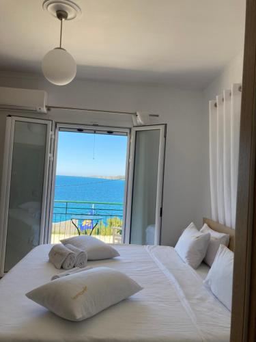 a bedroom with a bed with a view of the ocean at Studios Angeliki in Lassi