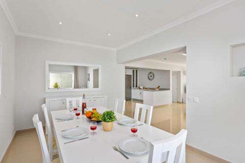 a white dining room with a white table and chairs at Villa Pianda by Villa Plus in Almancil