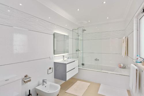 une salle de bain blanche avec un lavabo et des toilettes dans l'établissement Villa Pianda by Villa Plus, à Almancil