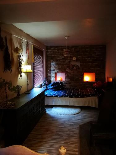 a bedroom with a bed and a brick wall at Pas Ligita in Biržai