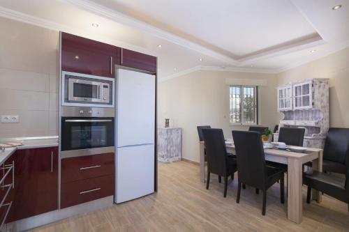 a kitchen and dining room with a table with chairs at Villa Siroco by Villa Plus in Albufeira