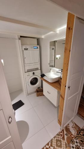 a bathroom with a sink and a washing machine at uniquechambre Gdynia in Gdynia
