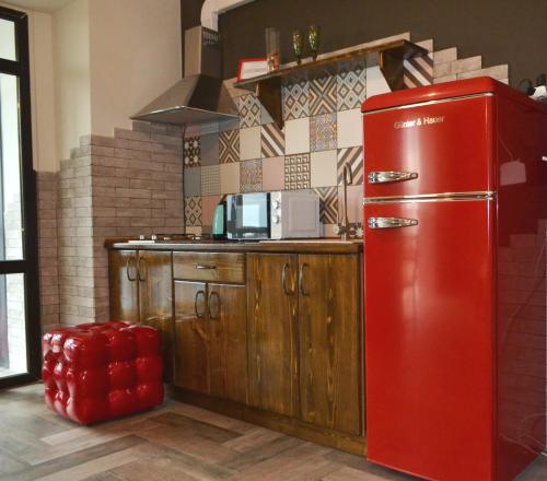 ein roter Kühlschrank in einer Küche mit Theke in der Unterkunft Апартаменты ПРЕМЬЕР in Kamjanez-Podilskyj