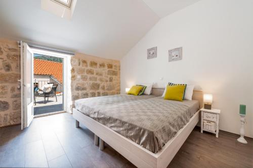 a bedroom with a bed with yellow pillows and a window at Villa Ane in Čelopeci