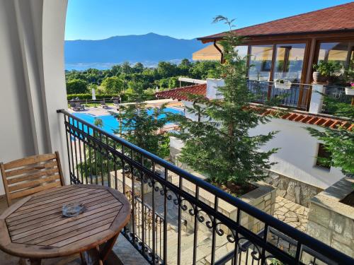 balcón con mesa y vistas a la piscina en Agnanti Hotel, en Velventós