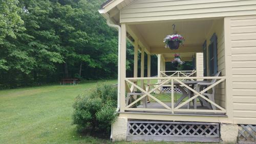 a porch of a house with a flower pot on it at Serenity Motel in Shaftsbury