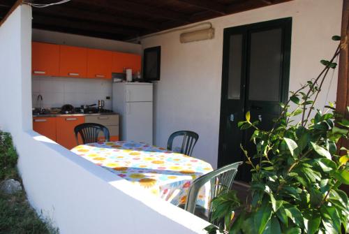 マッティナータにあるLeonardo Casa Vacanzeのオレンジ色のキャビネット付きのキッチン(テーブル、椅子付)