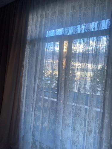 a view of a window with a white curtain at Queen Tamar in Batumi